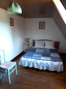 a bedroom with a bed and a chair in a room at Maison Quercynoise in Corn