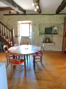 a dining room with a table and chairs and a television at Maison Quercynoise in Corn