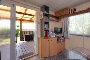 a living room with a door open to a deck at Mobilhome kervoyal 56 in Damgan