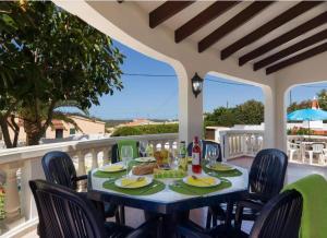a table on a balcony with a table and chairs at Casa Dos Mas in Cala en Porter