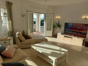a living room with a couch and a flat screen tv at Casa Dos Mas in Cala en Porter