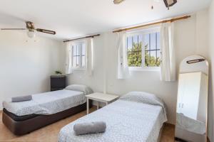 two beds in a room with two windows at Arizona in Pozo de los Palos +16 photos