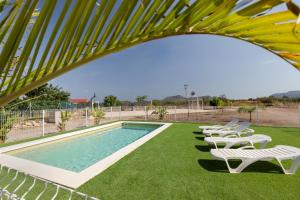 a group of white chairs sitting next to a swimming pool at Arizona in Pozo de los Palos