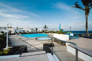 a resort with a swimming pool and the ocean at Bungalow 9 - Caleta Campos in Arrieta