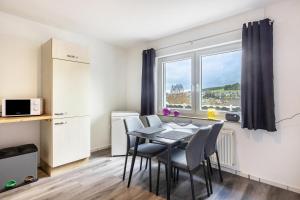 a dining room with a table and chairs and a window at Ferienwohnung Esselsteigblick in Eslohe