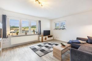 a living room with a couch and a tv at Ferienwohnung Esselsteigblick in Eslohe