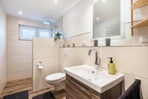 a white bathroom with a sink and a toilet at Ferienwohnung Esselsteigblick in Eslohe +12 photos