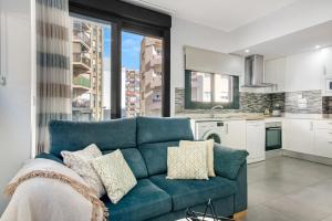 a living room with a blue couch and a kitchen at Calpe Beach in Calpe