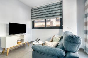a living room with a blue couch and a tv at Calpe Beach in Calpe