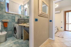 a bathroom with a sink and a washing machine at Casa Fiamma in Stintino +25 photos