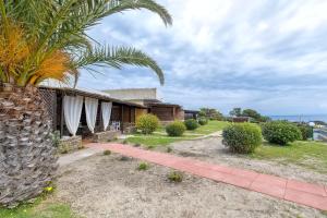 a house with a palm tree in front of it at Casa Fiamma in Stintino