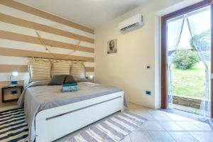 a bedroom with a bed and a large window at Casa Fiamma in Stintino