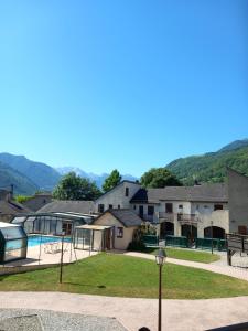 a resort with a swimming pool and mountains in the background at Appartement Bielle 106 in Bielle