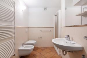 a white bathroom with a toilet and a sink at Residence Larice Bianco App n5 in Campodolcino +17 photos