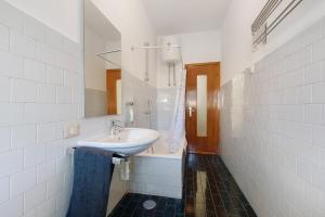 a white bathroom with a sink and a mirror at La terrazza sull’Adda in Malgrate