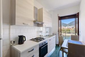 a kitchen with a stove top oven next to a table at La terrazza sull’Adda in Malgrate