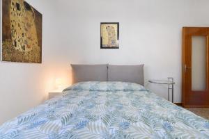a bed with a blue and white comforter in a bedroom at La terrazza sull’Adda in Malgrate