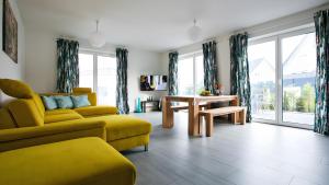 a living room with a yellow couch and a table at Apartment by Janzen -E- in Rheine