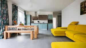a living room with a yellow couch and a table at Apartment by Janzen -E- in Rheine
