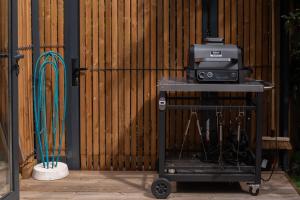 a television on a cart in front of a fence at Tipi Lodge Glamp Marguerite in Le Boulou