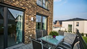 a patio with a glass table and chairs on a balcony at Apartment by Janzen -E- in Rheine