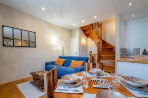 a living room with a table and a blue couch at Maison - Le Petit Bussac in Aigne