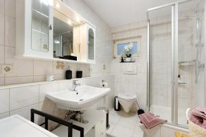 a white bathroom with a sink and a toilet at Ferienwohnung Ketterer in Hüfingen +22 photos