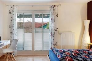 a bedroom with a blue couch and a window at Ferienwohnung Ketterer in Hüfingen