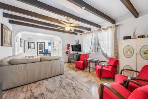 a living room with a bed and red chairs at Villa Marbella -pool - Beach At 300 in Marbella