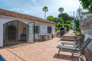 a patio with chairs and a table and a building at Villa Marbella -pool - Beach At 300 in Marbella