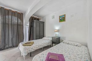 two twin beds in a room with a window at Villa Marbella -pool - Beach At 300 in Marbella +22 photos