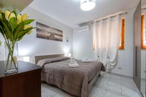 a bedroom with a bed and a vase of flowers at La casetta Bianca in Sassari