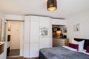 eine weiße Küche mit einem Bett in einem Zimmer in der Unterkunft Syltbrise 22 in Sylt