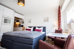 ein Schlafzimmer mit einem Bett, einem Tisch und Stühlen in der Unterkunft Syltbrise 22 in Sylt