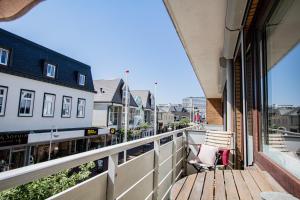 ein Balkon mit einer Holzbank an einem Gebäude in der Unterkunft Syltbrise 22 in Sylt