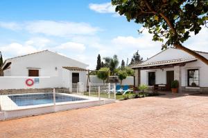 a villa with a swimming pool in front of a house at Villa Elsa in Conil de la Frontera