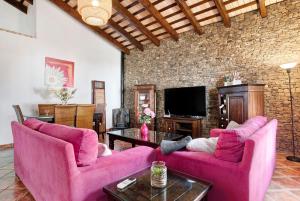 a living room with pink furniture and a brick wall at Villa Elsa in Conil de la Frontera