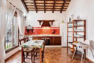 a kitchen with a table and a stove at Villa Elsa in Conil de la Frontera