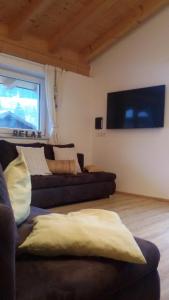 sala de estar con 2 sofás y TV de pantalla plana en Appartement Haus Petra, en Leogang