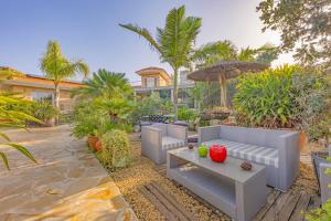 a garden with a couch and a table with fruit on it at Sconto in L'Alfàs del Pi