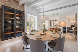a kitchen and dining room with a wooden table and chairs at Can Mas Villa Antigua in Pollença