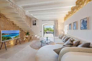 a living room with a white couch and a staircase at Can Mas Villa Antigua in Pollença