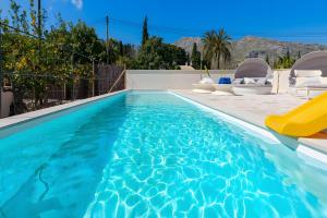 a swimming pool with a slide in a house at Can Mas Villa Antigua in Pollença