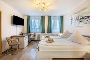 a hotel room with a bed and a desk at Pension Clara in Klipphausen