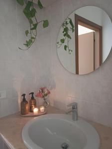a bathroom with a sink with a mirror and candles at Dream Room Apartment in Illasi +18 photos