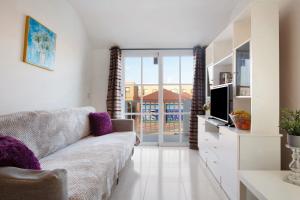 a living room with a couch and a tv at Casa sam in Caleta De Fuste