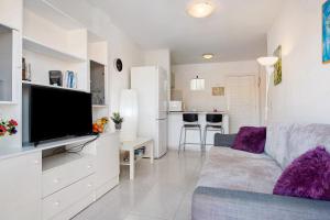 a living room with a couch and a flat screen tv at Casa sam in Caleta De Fuste