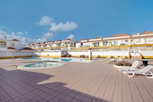 a courtyard with chairs and a pool in front of a building at Casa sam in Caleta De Fuste