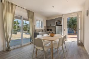 a kitchen and dining room with a table and chairs at Euphoria Apartments in Lixouri