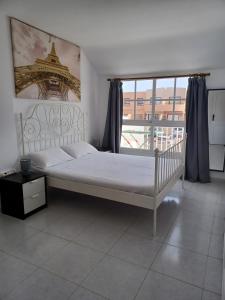 a bedroom with a white bed and a large window at Casa sam in Caleta De Fuste +14 photos